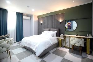 ein Schlafzimmer mit einem großen Bett und einem TV in der Unterkunft Baba Hotel Gimcheon in Gimcheon