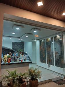 a restaurant with people sitting at a counter at Sagrado Hotel in Aguachica