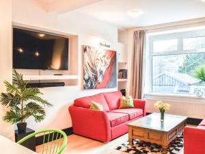 a living room with a red couch and a tv at Afan Adventure in Cymmer