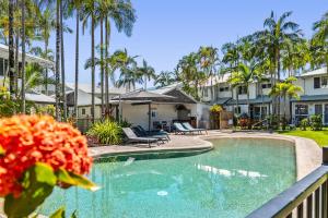 a swimming pool in a resort with palm trees at Coco Bay Resort in Noosaville