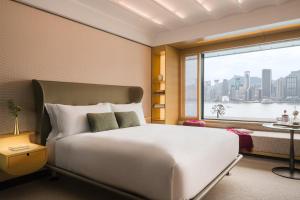 - une chambre avec un grand lit blanc et une fenêtre dans l'établissement Regent Hong Kong, à Hong Kong
