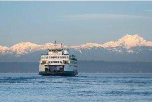 a large boat on the water with mountains in the background at Beautiful home, Central location, Close to Beach in Seattle
