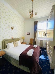 a hotel room with a bed and a window at The Esplanade Hotel in Auckland