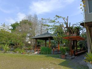 a garden with a gazebo and benches at Kamiyamato B&B in Guangfu