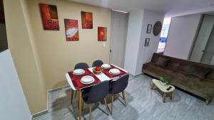 a living room with a table and chairs and a couch at Hermoso Apartamento Entero - Parqueadero - Ibague - Roble in Ibagué