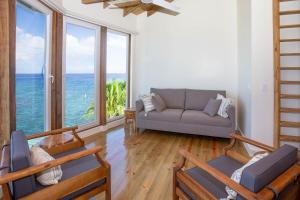 a living room with a couch and some windows at Stunning views at - Villa Aire apts in Roatan