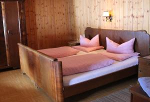 Bett mit rosa Kissen darauf in einem Zimmer in der Unterkunft Knappenhaus in Rauris