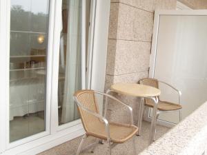 a small table and two chairs on a balcony at Pension Playa Mar Cachadiñas in Balea