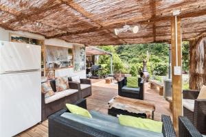 an outdoor living room with furniture and a refrigerator at Riverside Accommodation in Karangahake