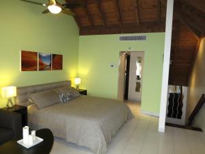 a bedroom with a bed and a living room at Luxury Beachfront Duplex Villa on Sapphire Beach I in East End