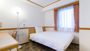 那覇市にある東横INN那覇国際通り美栄橋駅のベッドと窓が備わる小さな客室です。