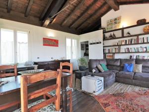 a living room with a couch and a table at Rustic Holiday Home in Montemarzino with Garden in Casasco