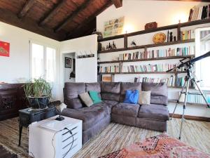 a living room with a couch and a book shelf at Rustic Holiday Home in Montemarzino with Garden in Casasco