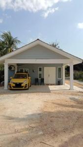a yellow car parked in front of a house at CMS HOMESTAY ALOR SETAR in Alor Setar