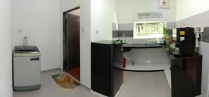 een keuken met een bureau met een computer en een vuilnisbak bij CMS HOMESTAY ALOR SETAR in Alor Setar