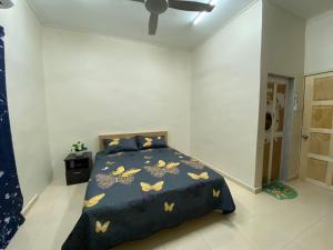 um quarto com uma cama com um cobertor azul com borboletas em CMS HOMESTAY ALOR SETAR em Alor Setar
