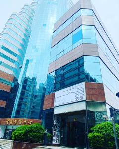 un edificio alto de cristal frente a una ciudad en Dayin International Youth Hostel East Nanjing Road & The Bund en Shanghái