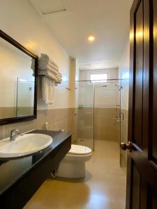La salle de bains est pourvue d'un lavabo, de toilettes et d'une douche. dans l'établissement Hotel Mỹ Mỹ, à Tây Ninh