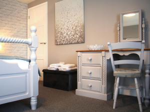 sypialnia z łóżkiem, komodą i krzesłem w obiekcie Townend Cottage w mieście Aikton
