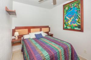 1 dormitorio con 1 cama y una pintura en la pared en Alpha's Place - Unit 3C, en Sandy Bay