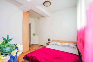 a bedroom with a large bed with a red blanket at Apartamenty Motylem Jestem in Szczawnica