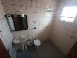 a bathroom with a sink and a toilet and a mirror at Casa da Frente Santa Felicidade in Curitiba +37 photos