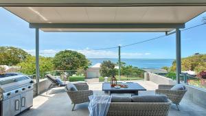 eine Terrasse mit einem Grill, einem Tisch und Stühlen in der Unterkunft Dutchie's Sand & Sea Beach House - easy walk to the beach in Nelson Bay