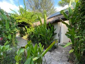 a small house with a door in a garden at Tipsea Turtle Gili Air in Gili Air