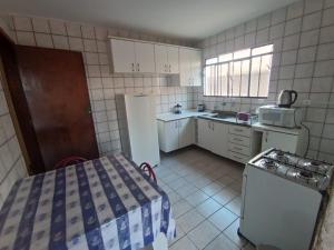 a small kitchen with a refrigerator and a sink at Casa da Frente Santa Felicidade in Curitiba