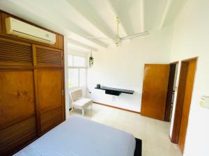 1 dormitorio con cama y escritorio en Uchuva beach house, en Santa Marta