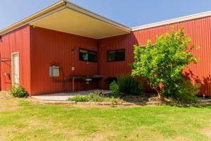 a red building with a picnic table in front of it at Bellarine Lodge Sleeps 30 in Drysdale
