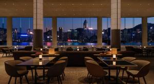 a restaurant with tables and chairs and a view of a city at Regent Hong Kong in Hong Kong
