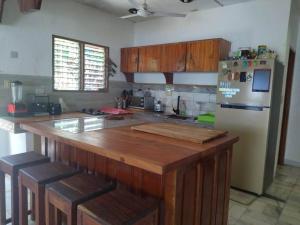 eine Küche mit einer Holztheke und einem Kühlschrank in der Unterkunft Transient House in Puerto Galera