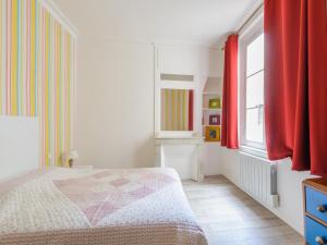 ein weißes Schlafzimmer mit roten Vorhängen und einem Bett in der Unterkunft Appartement La Rochelle, 2 pièces, 2 personnes - FR-1-535-44 in La Rochelle