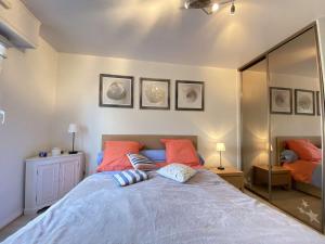 ein Schlafzimmer mit einem großen Bett mit orangefarbenen Kissen in der Unterkunft Appartement Pornichet, 2 pièces, 4 personnes - FR-1-245-180 in Pornichet