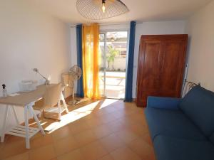 ein Wohnzimmer mit einem blauen Sofa und einem Tisch in der Unterkunft Villa Le Grau-du-Roi, 5 pièces, 8 personnes - FR-1-307-226 in Le Grau-du-Roi