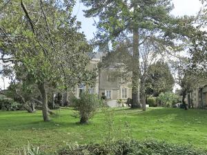 a house with a yard with trees and green grass at Maison de maître avec piscine et jardin - cœur des Coteaux du Layon, proche Angers et Saumur - FR-1-622-55 in Faye-dʼAnjou