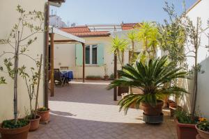 a courtyard with potted plants and a house at La Papaya in Marina di Pisa