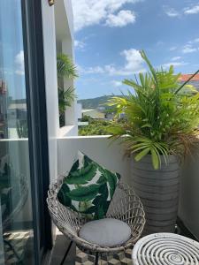 uma cadeira numa varanda com uma planta em Green River Boutique Hotel em Vung Tau