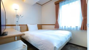 Postel nebo postele na pokoji v ubytování Toyoko Inn Kobe Sannomiya-eki Higashi
