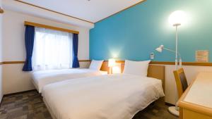 2 camas en una habitación con paredes azules en Toyoko Inn Yokohama Stadium Mae No 2, en Yokohama