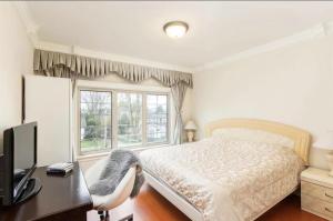 een slaapkamer met een bed, een bureau en een raam bij An Yang House in Burnaby
