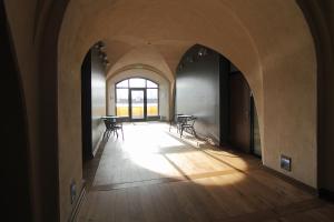 an arched hallway with tables and chairs in a building at Daugavpils Mark Rothko Art Center residences in Daugavpils