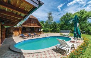 Gračanica的住宿－3 Bedroom Beautiful Home In Lekenik，一个带两把椅子和遮阳伞的游泳池