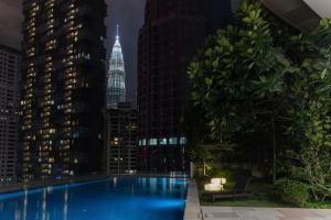 a swimming pool with a city skyline at night at Bukit Bintang Signatures by Premium Hospitality in Kuala Lumpur