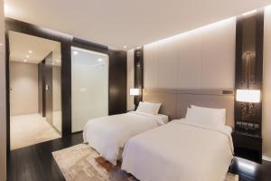 een slaapkamer met 2 bedden en een spiegel bij Bukit Bintang Signatures by Premium Hospitality in Kuala Lumpur