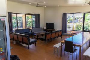 a living room with tables and chairs and windows at Bellarine Lodge Sleeps 30 in Drysdale