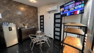 a room with a table and chairs and a refrigerator at Hotel Family House Rodadero in Santa Marta