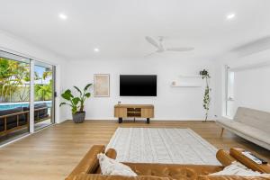 a living room with a couch and a tv at Luxury home in the heart of Burleigh in Gold Coast