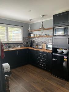 kuchnia z czarnymi szafkami i blatem w obiekcie Mahalo BnB w mieście Mapleton
